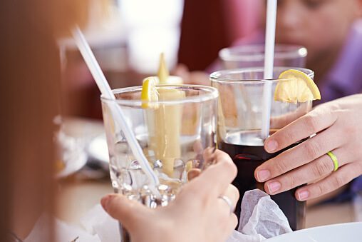 Hands of two teenagers toasting with cola