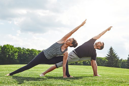 couple-stretching-young-couple-stretching-and-doing-yoga-exercises-in-picture-id1139108800