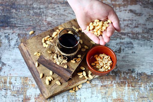 glass-of-black-soda-drink-and-peanuts-picture-id1343236376