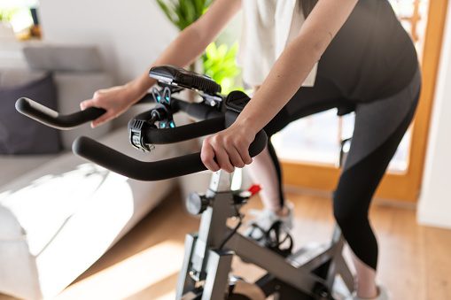 low-section-of-woman-training-on-exercise-bike-at-home-picture-id1223590138