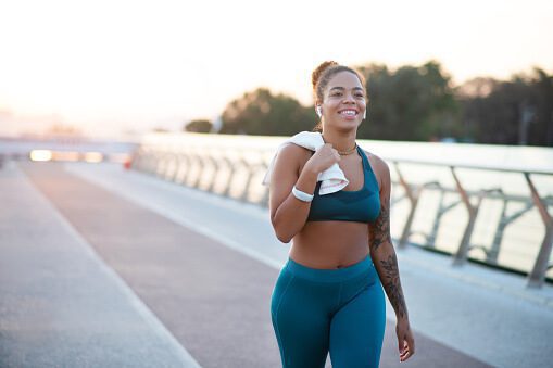 tattooed-young-woman-going-home-after-running-in-the-morning-picture-id1179353479