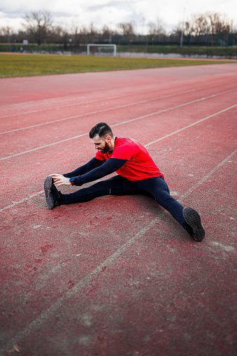 Young man stretching after intensive work out
